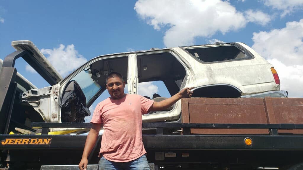 Owner of Top Dollar For Junk Cars with a junk SUV loaded on a tow truck in Chattanooga, TN